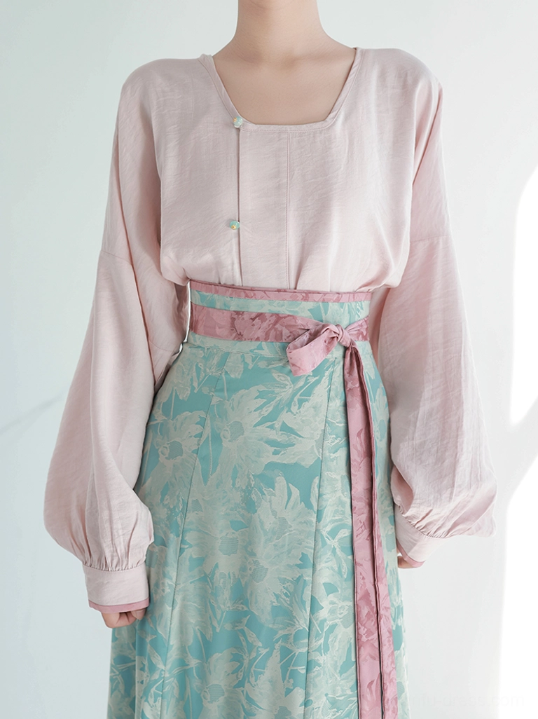 Close-up detail of Tiffany Glaze Tang Dynasty Hanfu round collar top green buttons pink waistband and cyan printed skirt