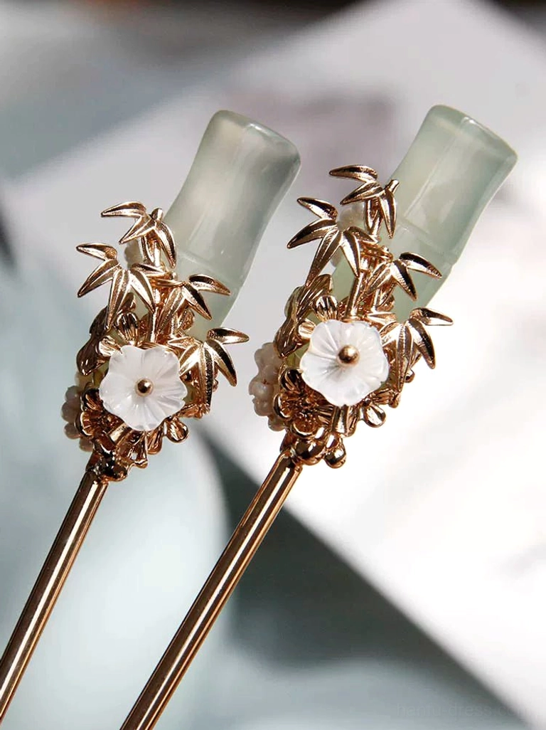 Detailed view of traditional Chinese bamboo hairpins featuring jade green bamboo joints gold metalwork and floral accents