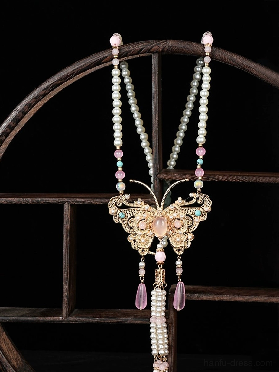 Traditional Chinese butterfly tassel necklace featuring a pink center stone gold pendant pearl chains teardrop charms and decorative back tassels