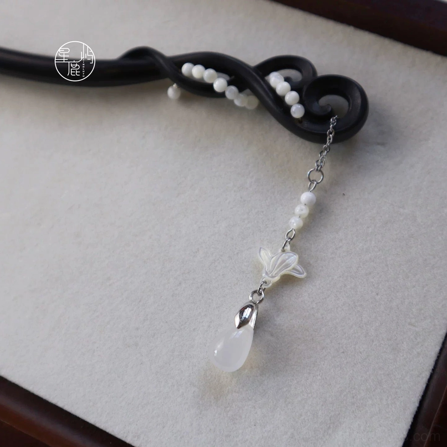 Traditional Chinese decorative hairpin with black scrollwork wooden body, clustered white beads, shell flower charm, and clear water drop pendant