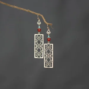 Traditional Chinese earrings with gold tone carved window pendant, turquoise and red agate beads, cloud motif ear hooks, retro Hanfu jewelry on dark gray background