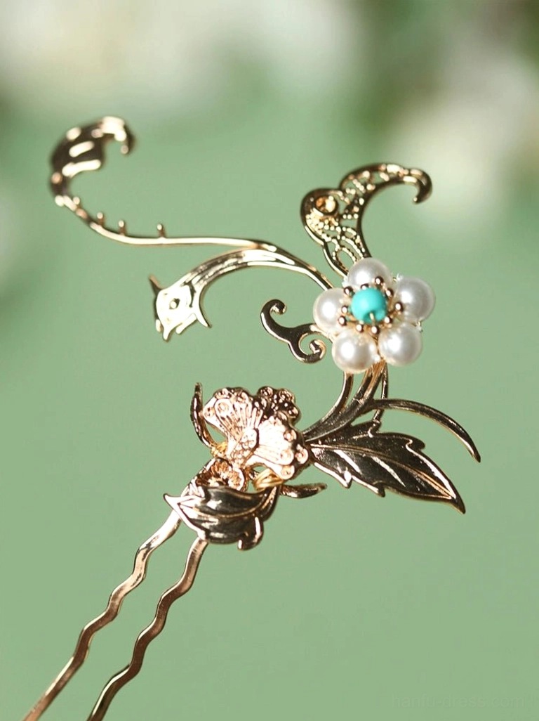 Three-quarter close-up view of a traditional Chinese floral hair pin with openwork gold-toned metal, imitation pearl, and turquoise-colored bead ornament