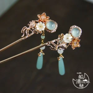 Traditional Chinese floral hair stick pair featuring pale blue jade style stones, white flower details, and rose gold tone metal