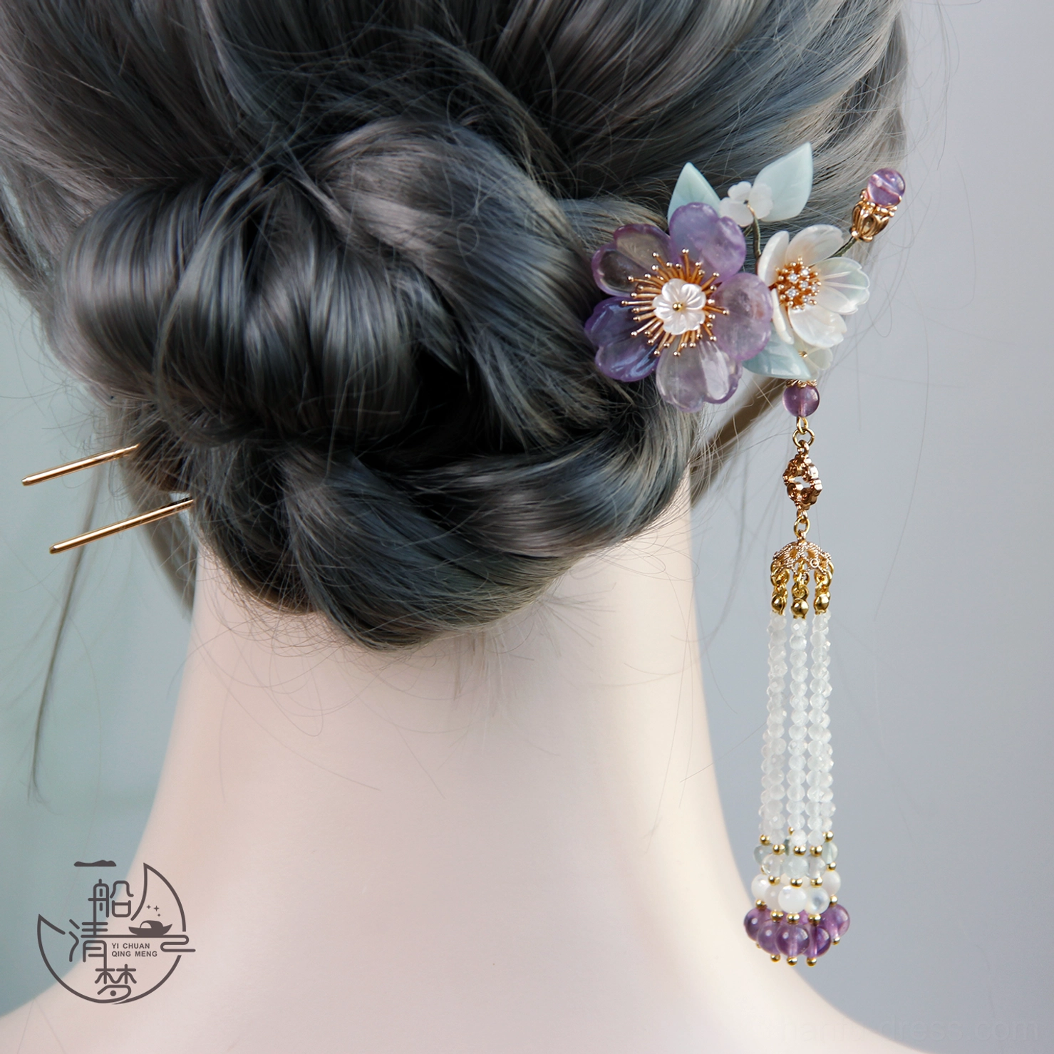 Traditional Chinese floral hair stick with long purple and white beaded tassel styled in a low Hanfu bun