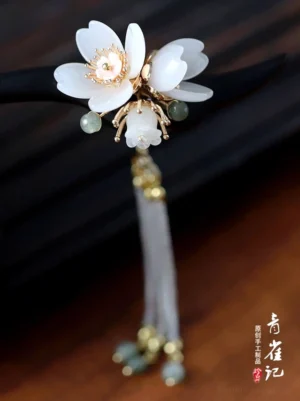 Front view of an elegant Chinese floral hair stick featuring white cherry-blossom-shaped flowers, gold-tone flower centers, green accent beads, and hanging bead pendants
