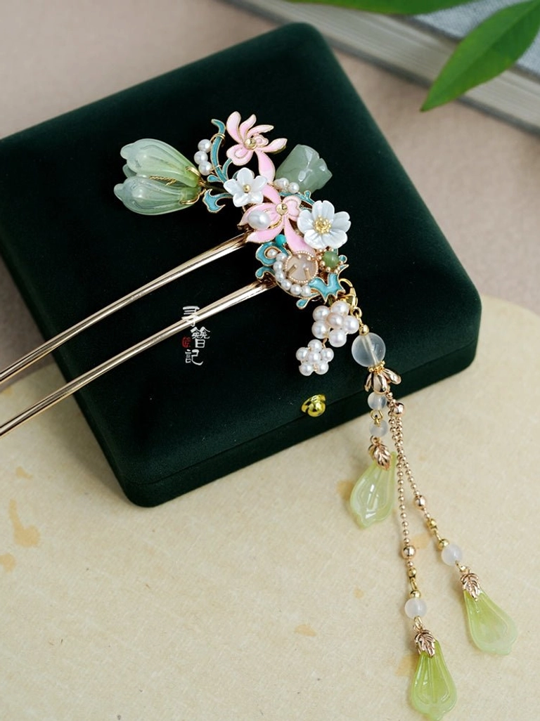 Traditional Chinese floral Hanfu hairpin with golden hair sticks, pink and white blossoms, green jade look buds, pearl details, and multiple green droplet pendants on a long decorative tassel
