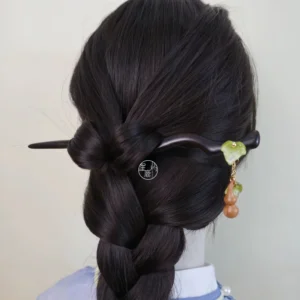 Full back view of a traditional Chinese gourd hair stick securing a braided Hanfu hairstyle, featuring a dark wooden shaft, green leaf ornament, hanging gourd charm, and red bead tassel details