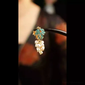 Traditional Chinese grape pearl hairpin accessory shown against a dark vintage floral outfit with detailed imitation pearl pendant