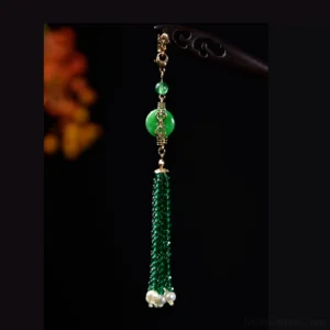 Traditional Chinese hair stick with long emerald crystal-style tassel, green jade-style disc charm, white pearl-like clusters, and gold-toned details