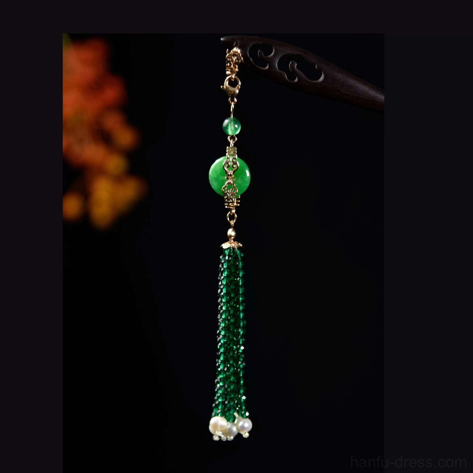 Traditional Chinese hair stick with long emerald crystal-style tassel, green jade-style disc charm, white pearl-like clusters, and gold-toned details