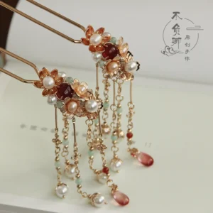 Traditional Chinese hair stick and tassel hair accessory featuring floral bead clusters white faux pearls red and gold accents on a vintage book