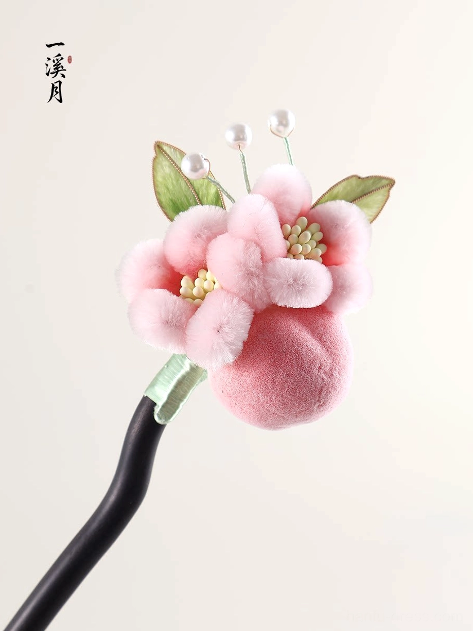 Traditional Chinese hair stick with soft pink velvet flower, visible flower center, green leaves, and pearl decorations