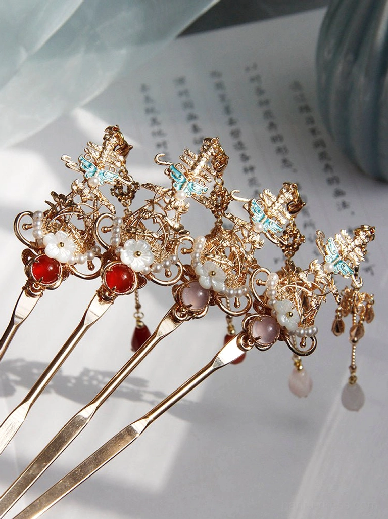 Flat lay of mixed traditional Chinese hair sticks featuring red and pink gemstone accents, gold filigree, floral ornaments and hanging tassels