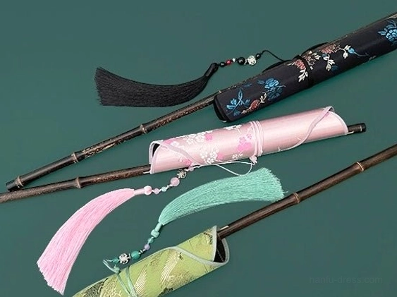 Assorted traditional Chinese hand fan storage sleeves with floral embroidery cherry blossom and textured green patterns paired with black pink and mint tassels