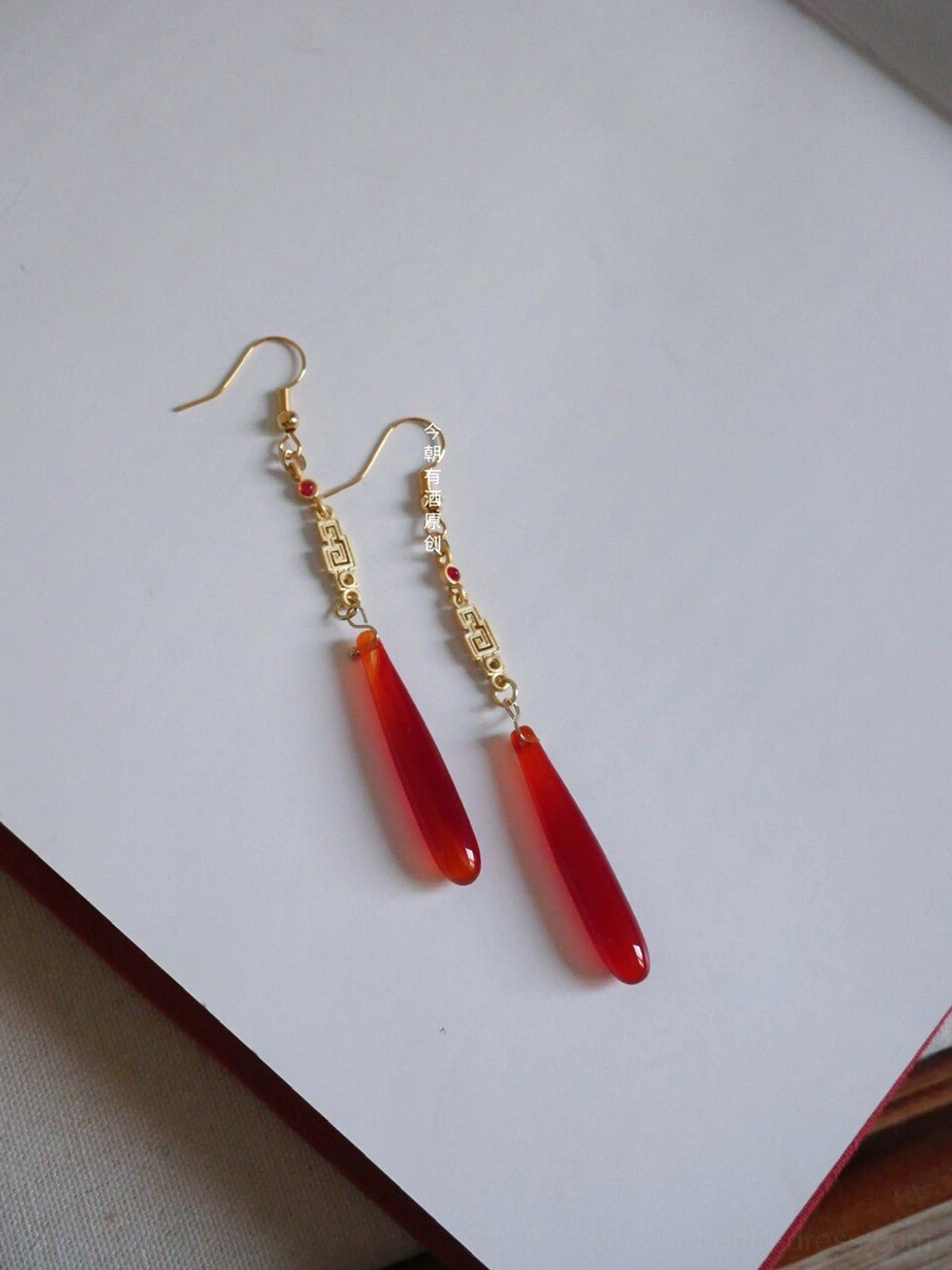 Pair of traditional Chinese Hanfu earrings with gold hooks, geometric fretwork links, red beads, and polished red teardrop agate pendants