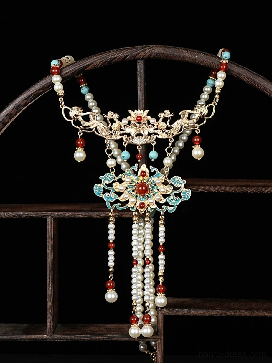 Full overhead view of a traditional Chinese hanfu necklace with carved gold-toned metalwork, cloisonne floral patterns, pearl-style beads, red accents, and layered tassel pendants