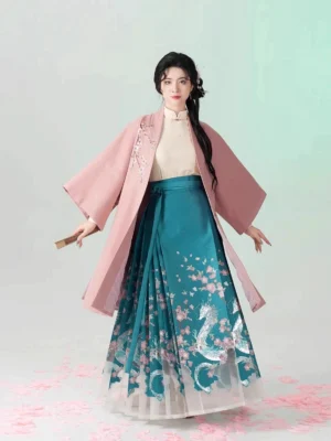 Full-body front view of a traditional Chinese hanfu outfit featuring a pink coat beige inner top and pleated teal mamian skirt with decorative embroidery