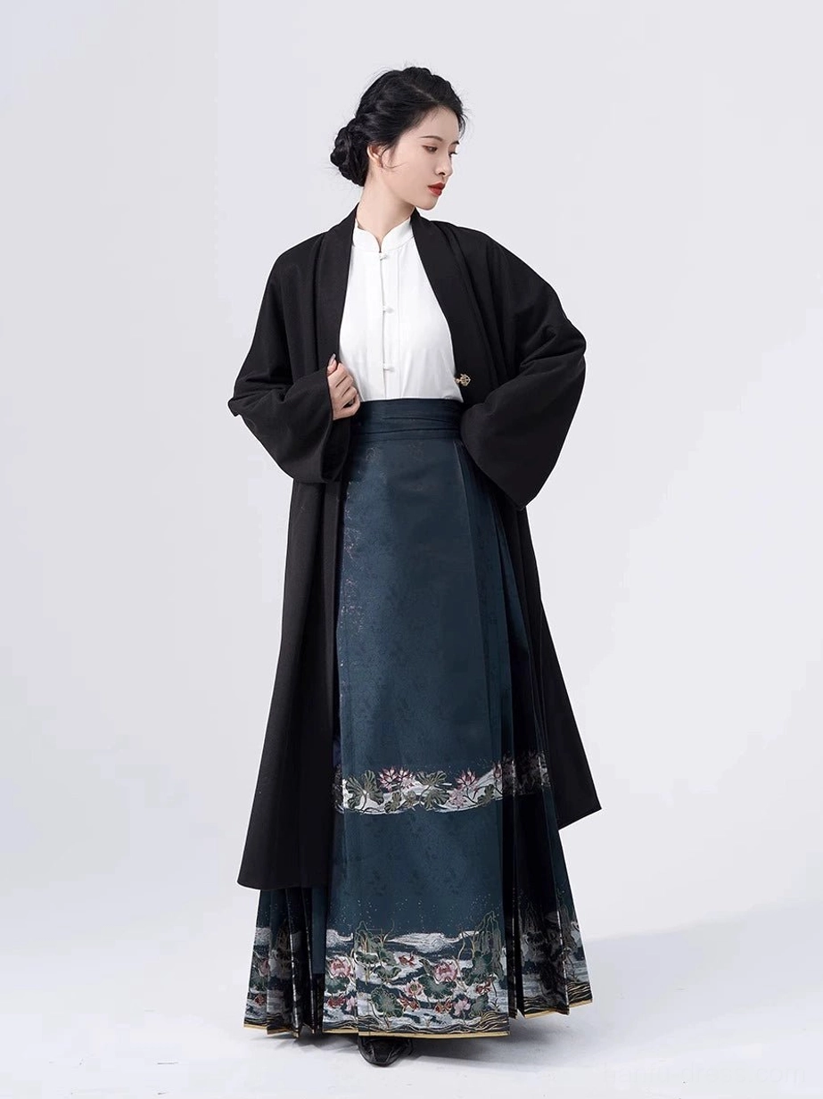Three-piece traditional Chinese Hanfu outfit with black open coat white blouse and dark teal embroidered skirt shown from the side