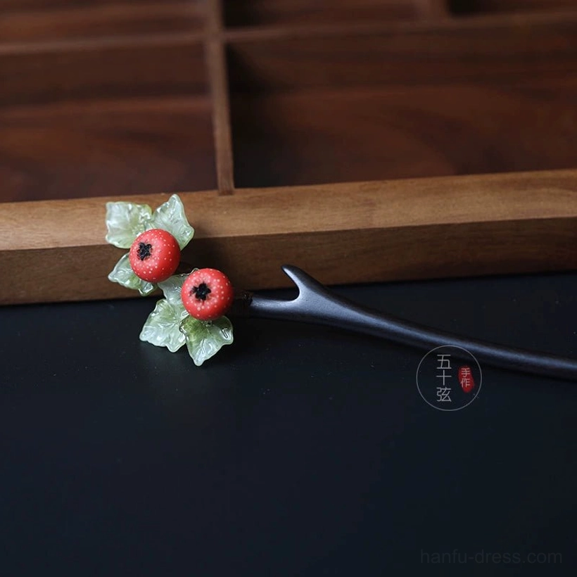 Traditional Chinese hawthorn hair stick shown from the side on a wooden display tray with dark wood styling