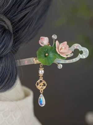 Traditional Chinese lotus hair stick secured in dark blue hair, showing the complete Hanfu hair accessory design with floral ornament and dangling charm