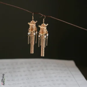 Side view of traditional Chinese palace pavilion drop earrings with delicate gold filigree, pearl pendants, and layered chain tassels for Hanfu styling