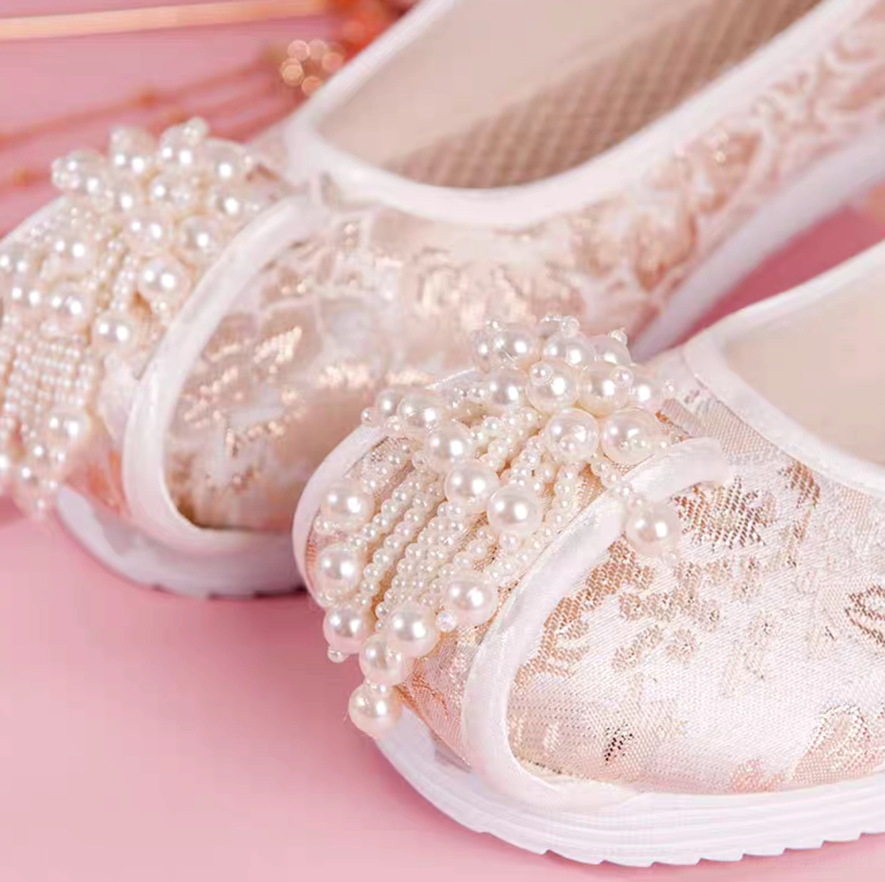 Close-up of traditional Chinese pearl Hanfu shoes showing delicate pearl tassel toe embellishments, floral jacquard texture, breathable fabric lining, and smooth white rubber outsole