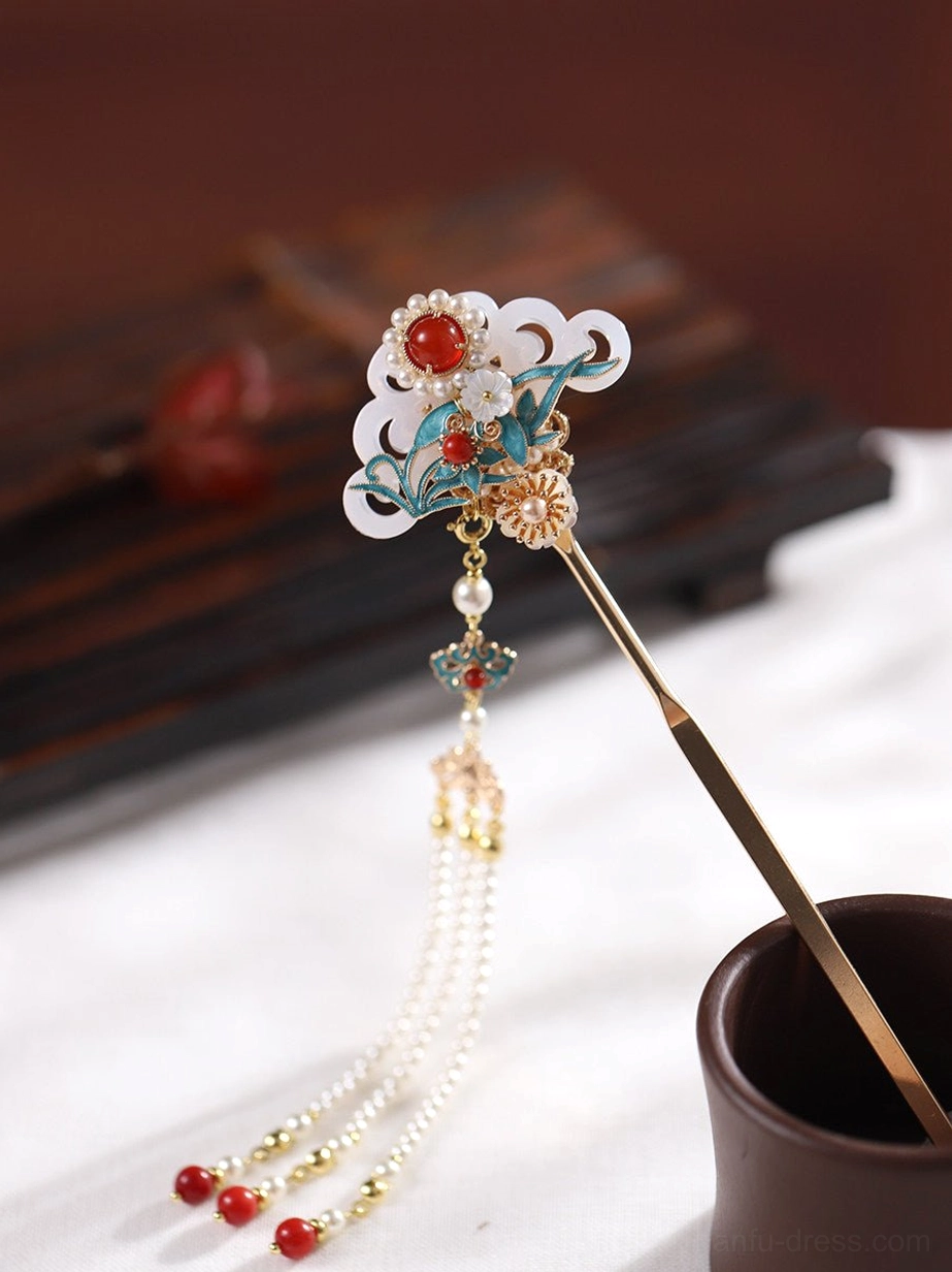 Left three-quarter view of a traditional Chinese tassel hair stick with gold ornamentation, colorful cloisonne-style details, and red bead pendants