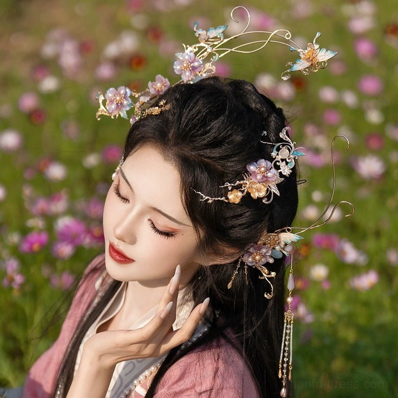 Close-up side view of traditional Hanfu hair accessories featuring curly gilded metal branches, purple flowers, and long decorative tassels