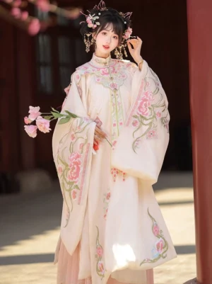 Traditional Chinese Ming Dynasty Hanfu clothing with floral embroidered cloud collar and pink skirt beside a red wooden pillar
