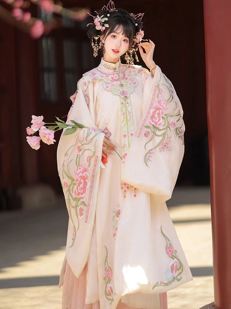 Traditional Chinese Ming Dynasty Hanfu clothing with floral embroidered cloud collar and pink skirt beside a red wooden pillar