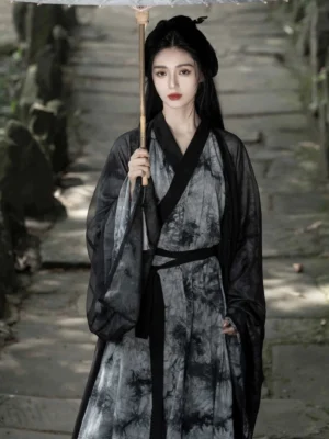 Traditional Wei Jin Dynasty ink wash Hanfu with layered cross-collar robe, black sash belt, and flowing silhouette styled with an oiled paper umbrella