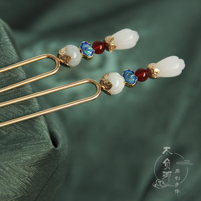 Side view of a traditional Yulan magnolia Chinese hairpin with layered white blossom, jade bead, red bead, blue cloisonne-style ornament, and double-pronged design