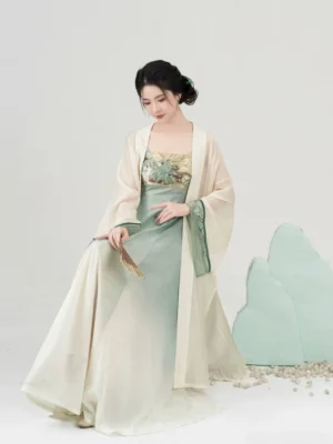 Modern Tang Dynasty Hanfu slip dress and long cardigan set shown in three-quarter side view with folding fan and green cuff trim
