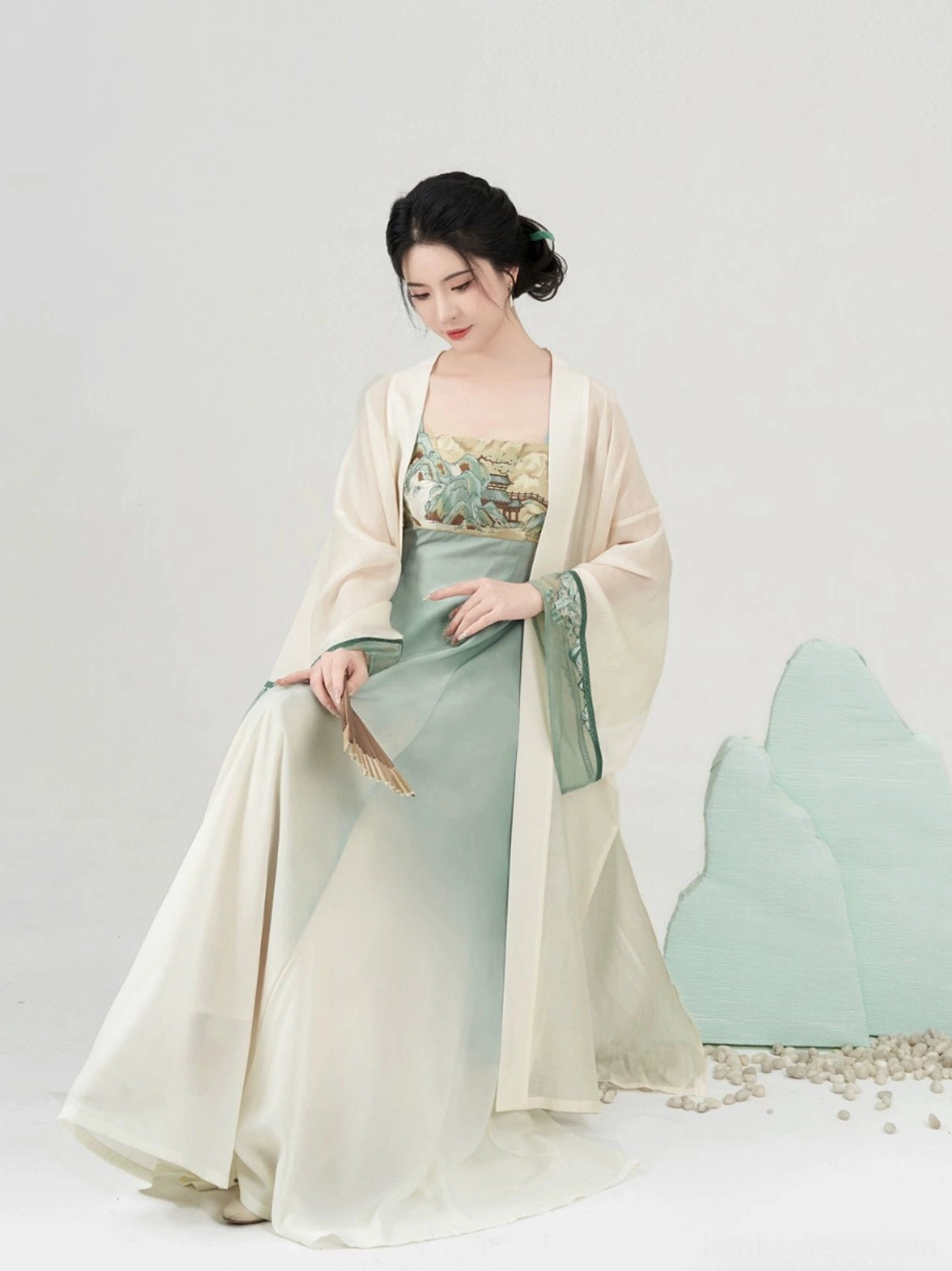 Modern Tang Dynasty Hanfu slip dress and long cardigan set shown in three-quarter side view with folding fan and green cuff trim