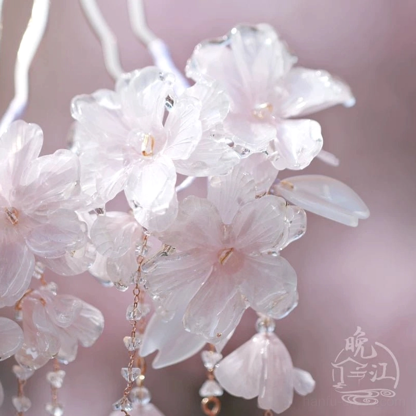 Detailed overhead view of translucent pink cherry blossom petals with visible vein patterns and fine tassels on a Chinese hair accessory