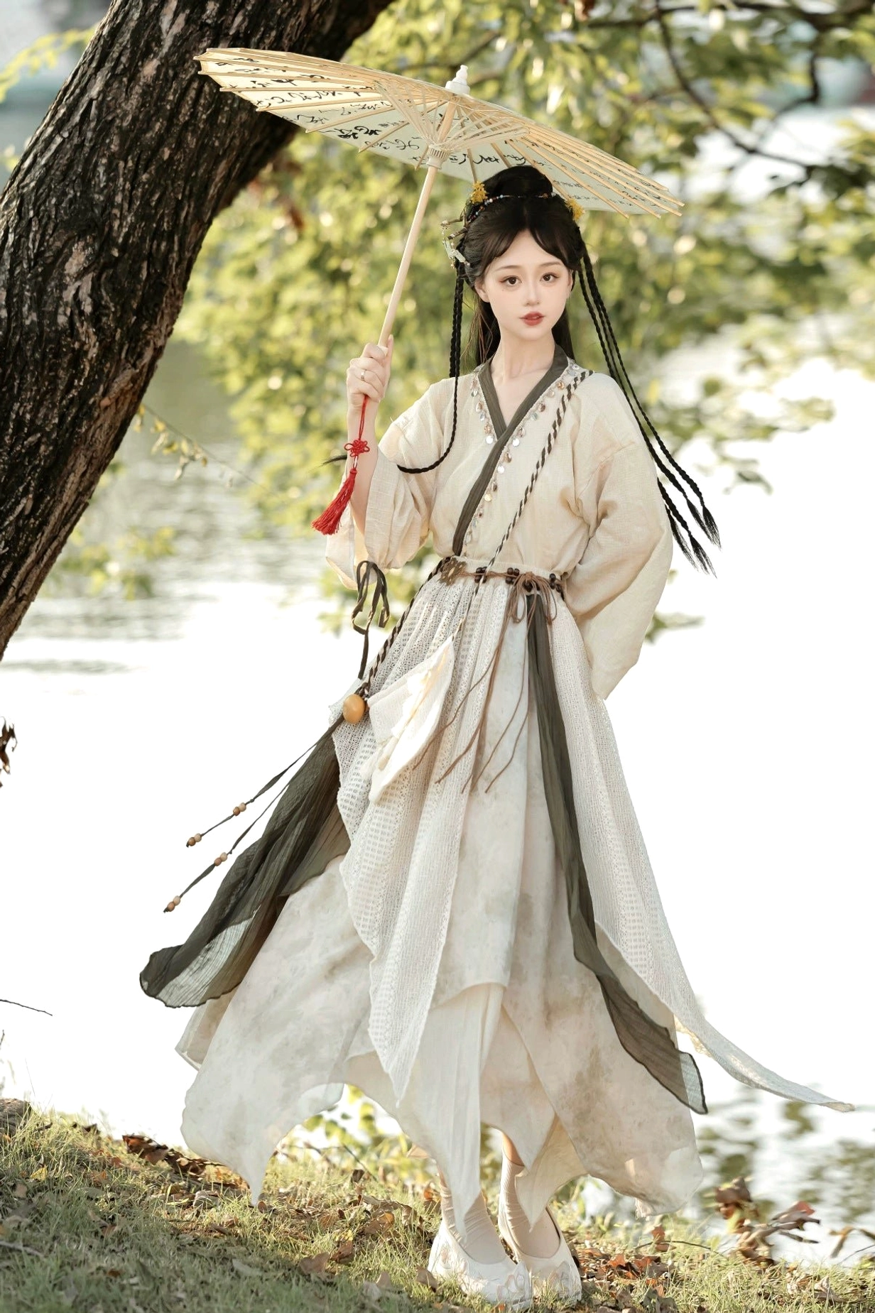 Travelling Lotus modern Hanfu complete set in beige and olive green with cross-collar top and layered asymmetrical skirt by a lakeside