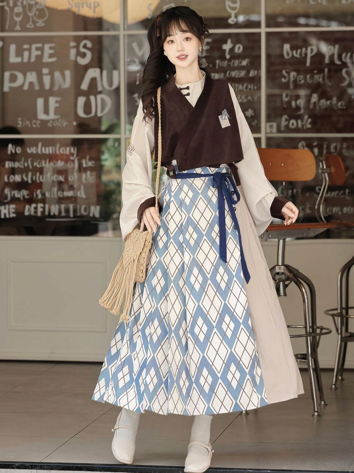 Modern Chinese style Ming Dynasty Hanfu set worn in cafe with embroidered brown vest beige top and blue patterned mamian skirt