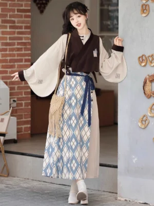 Front three-quarter view of Travels in the Mountains modern Ming Dynasty Hanfu set with beige wide-sleeved top brown embroidered vest and blue mamian skirt