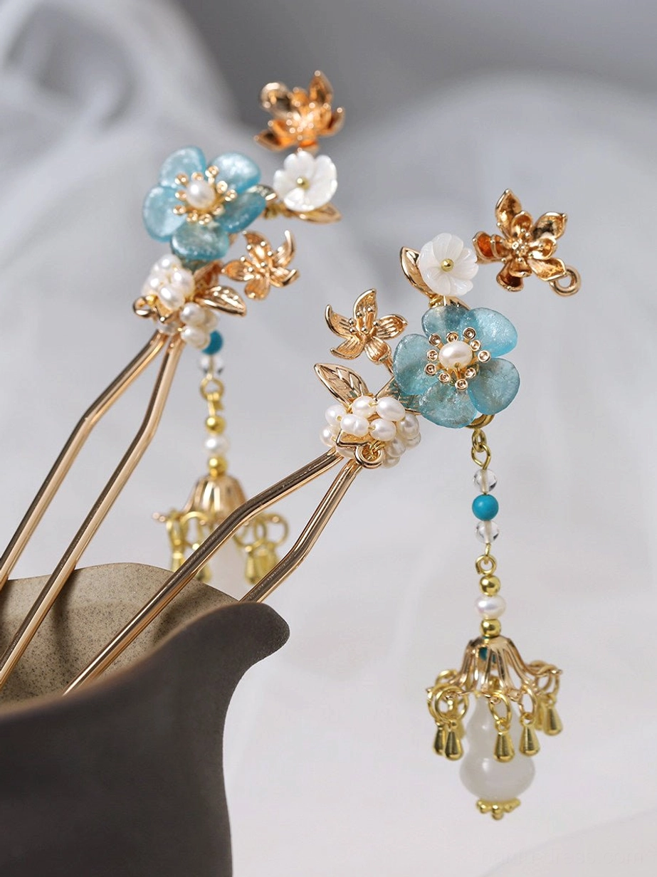 Matching left and right turquoise blossom Chinese hair sticks with white floral accents pearl beads and elegant dangling tassels on sheer fabric