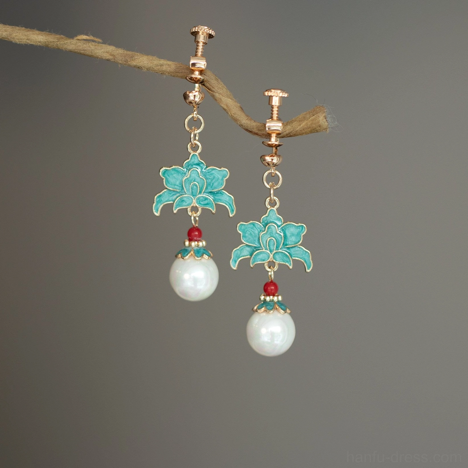 Turquoise cloisonne lotus pearl screw-back clip-on Chinese earrings shown from a low angle with gold toned fittings