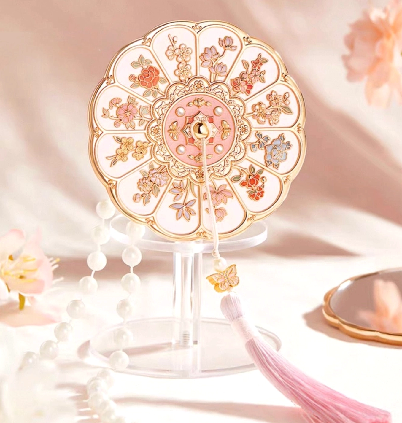 Elegant Twelve Flower Goddesses Chinese pocket mirror displayed on an acrylic stand with peach blossoms and pearl ornaments