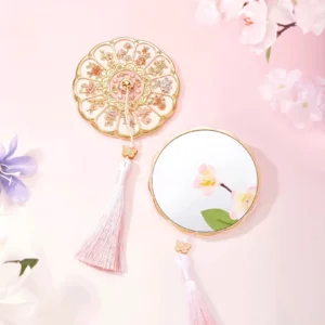 Twelve Flower Goddesses Chinese pocket mirror with petal-shaped floral cover, pink tassel, and pastel flower background
