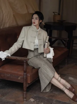 Woman wearing a Twilight modern Hanfu cropped blazer and plaid midi skirt with a lace lotus leaf shirt in a vintage indoor studio