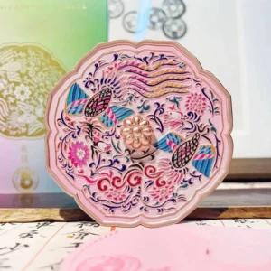 Front view of a decorative twin phoenix Chinese pocket mirror lid with colourful flowers, curling vines, turquoise and purple details, scalloped begonia shape, and rose gold centre accent
