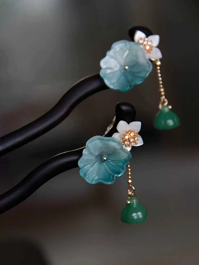 Two lotus themed Chinese hair stick styles with black wooden shafts, blue lotus flowers, white floral details, green lotus pod pendant, and carved green pendant