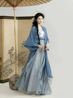 Two-tone blue Song Dynasty Hanfu dress and wide-sleeve cardigan shown from a left three-quarter view with a traditional Chinese landscape screen and oiled paper umbrella