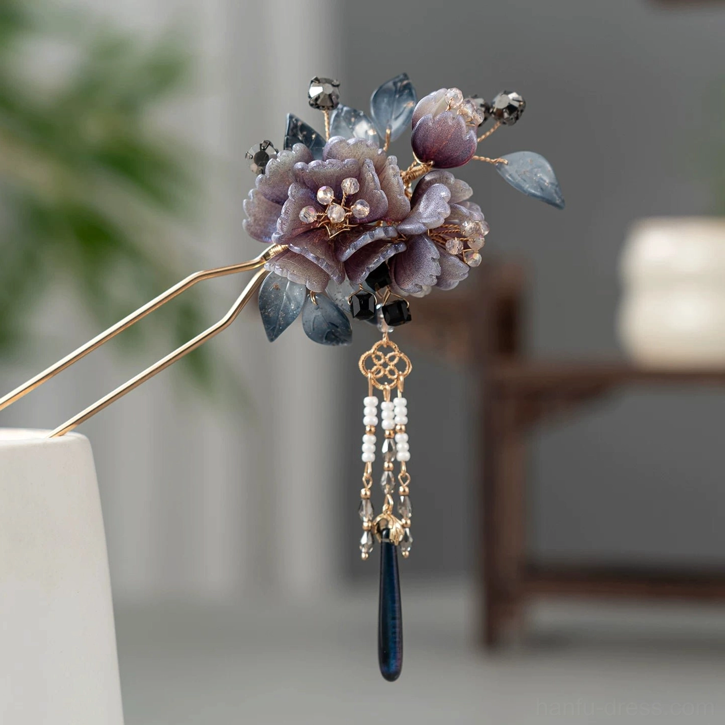 U-shaped mauve peony flower hairpin with blue resin leaves, gold-toned body, white beaded tassel, dark blue pendant, and Chinese knot charm