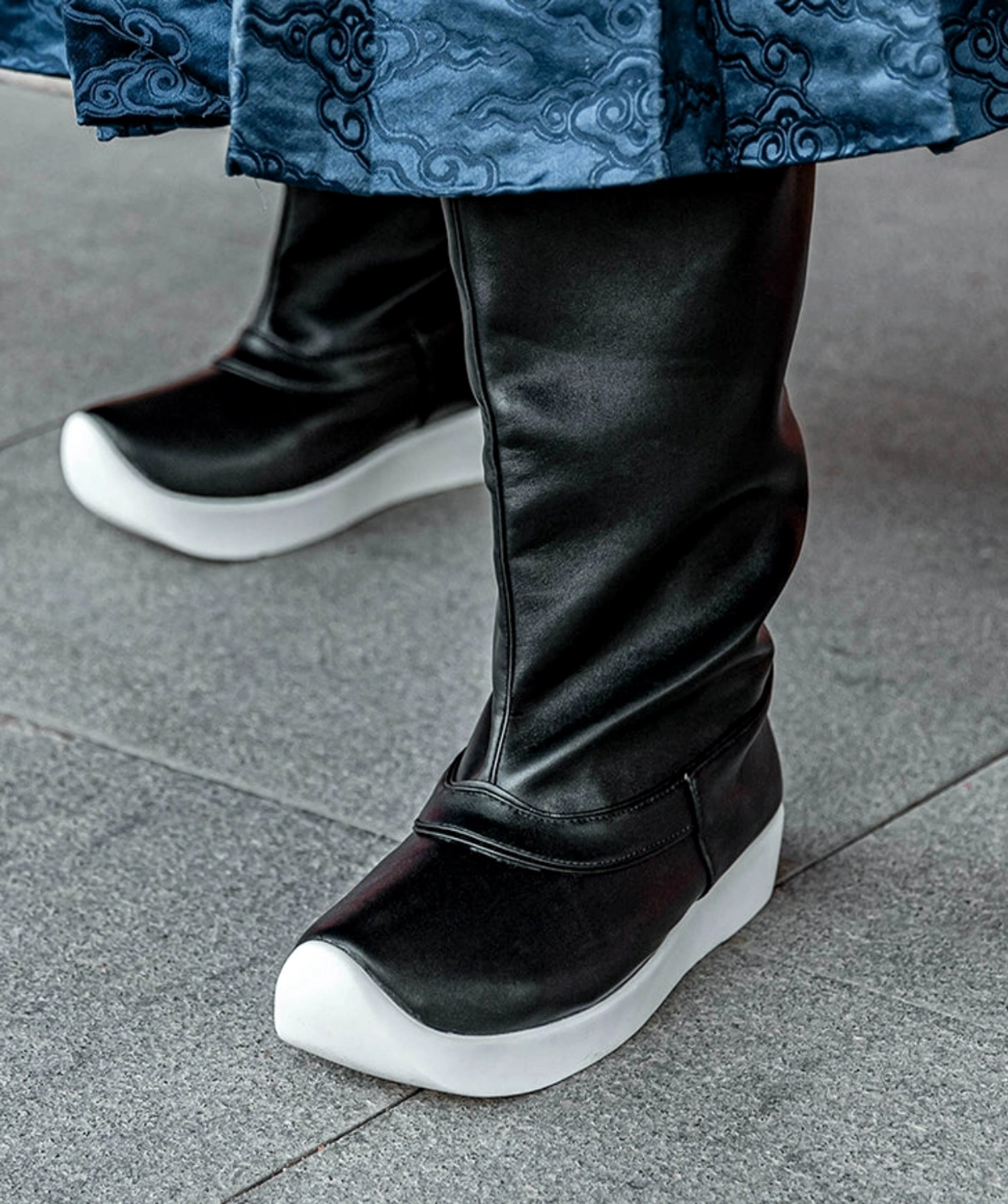Unisex black Hanfu boots worn with blue cloud pattern Hanfu skirt, featuring traditional upturned toe and white platform sole