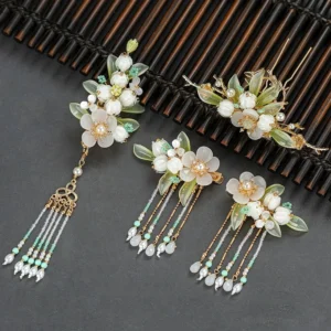 Complete Valley Hanfu hair accessories set with milky white resin flowers light green leaves gold-tone frames green beads and pearl-style tassels displayed on a dark bamboo mat