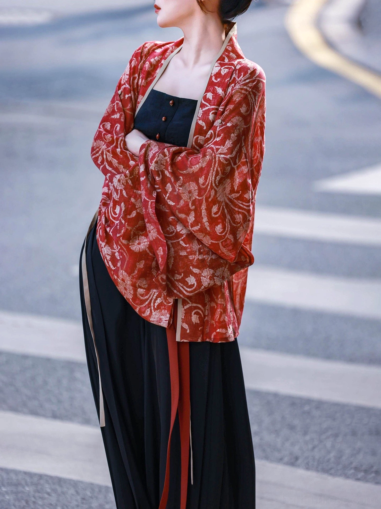 Side view of a Vermilion Bird Song-style Hanfu outfit showing the relaxed red cardigan fit long waist ribbons and flowing black trousers